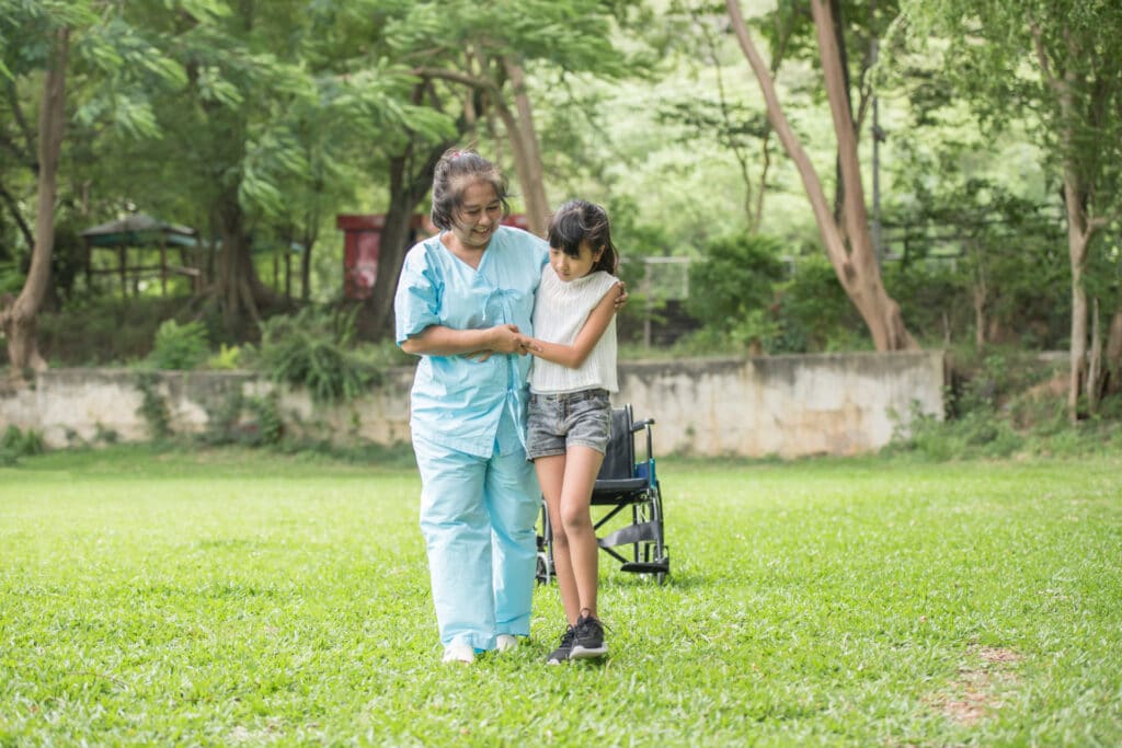 elderly grandmother wheelchair with granddaughter hospital garden
